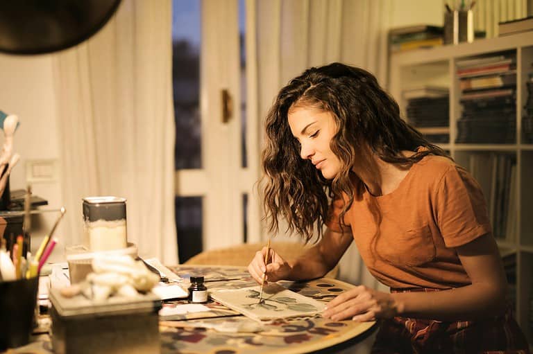 Young woman painting for her creative side hustle